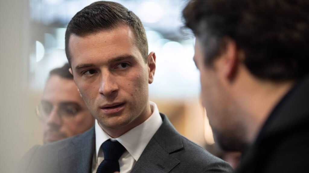 Jordan Bardella en discussion, posture droite soulignant sa taille imposante